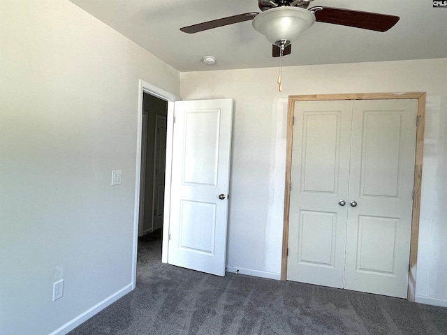 unfurnished bedroom featuring a closet, dark carpet, baseboards, and ceiling fan