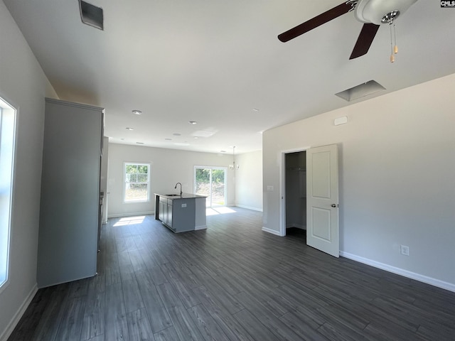 unfurnished room with ceiling fan, dark wood-type flooring, a sink, and baseboards