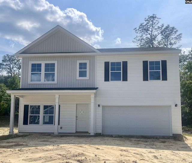 view of front of house featuring board and batten siding, covered porch, driveway, and an attached garage