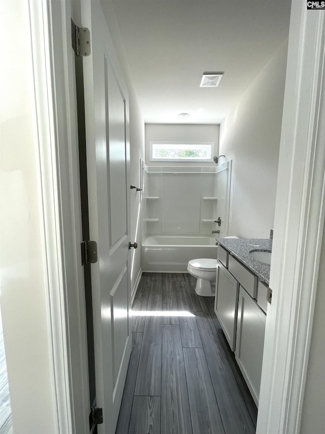 full bath featuring shower / bathtub combination, toilet, wood finished floors, vanity, and visible vents