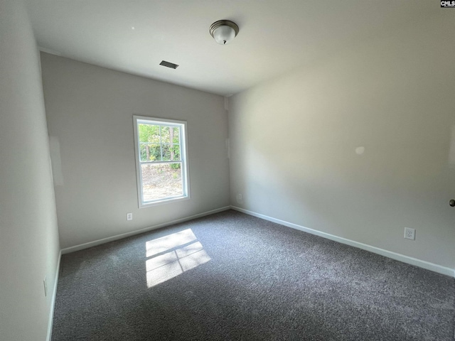 carpeted spare room featuring baseboards