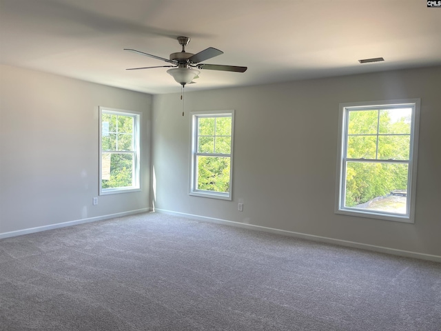 carpeted spare room with ceiling fan and baseboards