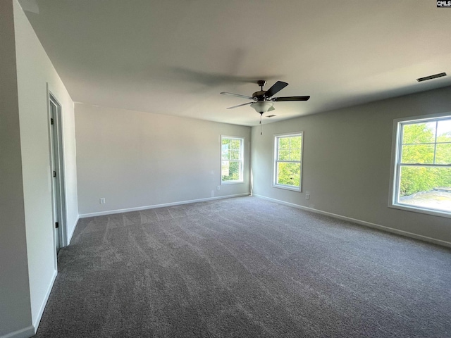 carpeted empty room featuring ceiling fan, visible vents, and baseboards