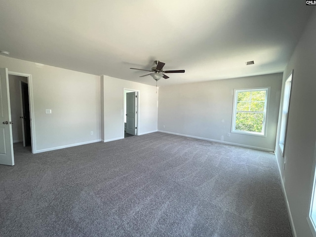 empty room with carpet floors, baseboards, and a ceiling fan