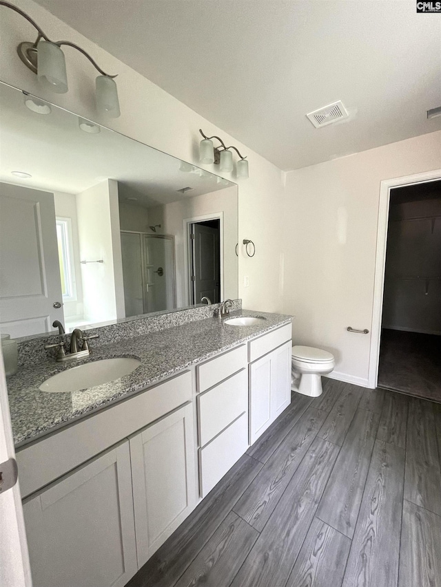 bathroom featuring a shower stall, visible vents, a sink, and wood finished floors