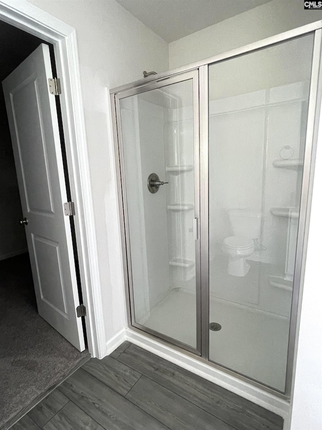 bathroom with a stall shower and wood finished floors