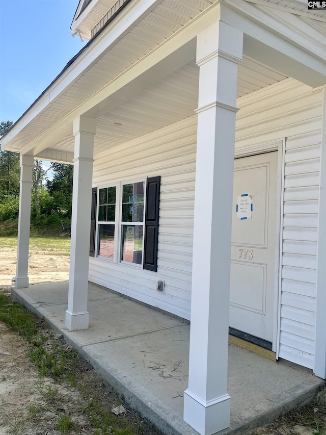 view of exterior entry featuring covered porch