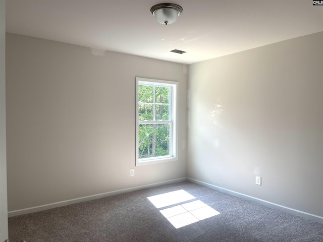 carpeted empty room featuring baseboards