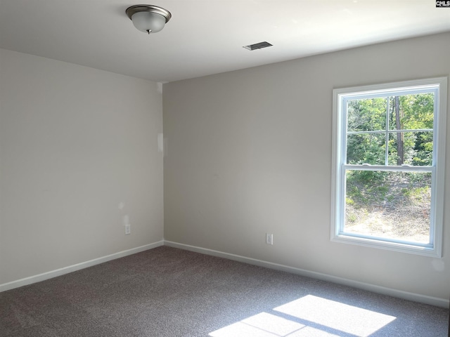 carpeted spare room featuring baseboards