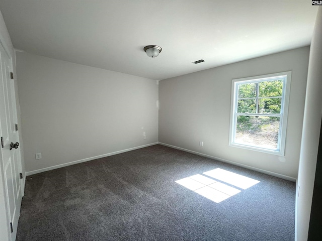 carpeted empty room featuring visible vents and baseboards