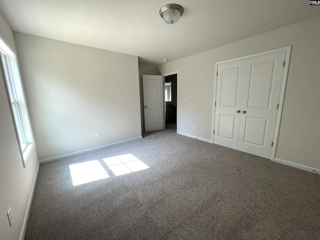 unfurnished bedroom with carpet floors, a closet, and baseboards