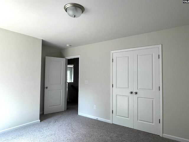 unfurnished bedroom with carpet floors, a closet, and baseboards