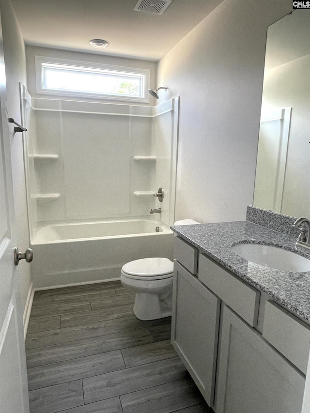 full bath with shower / washtub combination, visible vents, toilet, vanity, and wood finished floors