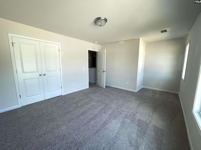 unfurnished bedroom with carpet floors, baseboards, and a closet