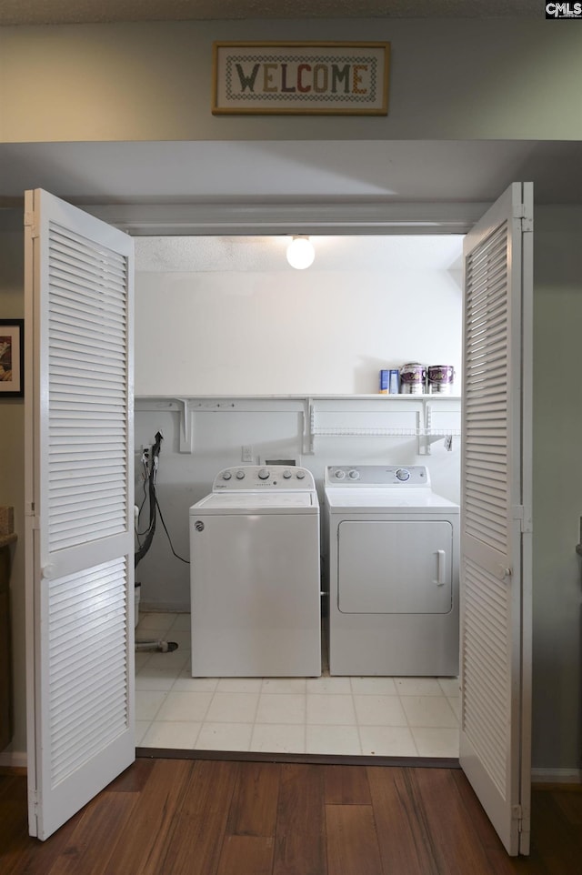 washroom featuring laundry area, separate washer and dryer, and wood finished floors