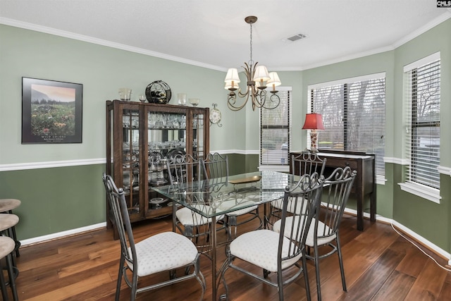 dining area featuring dark wood-type flooring, visible vents, ornamental molding, and baseboards