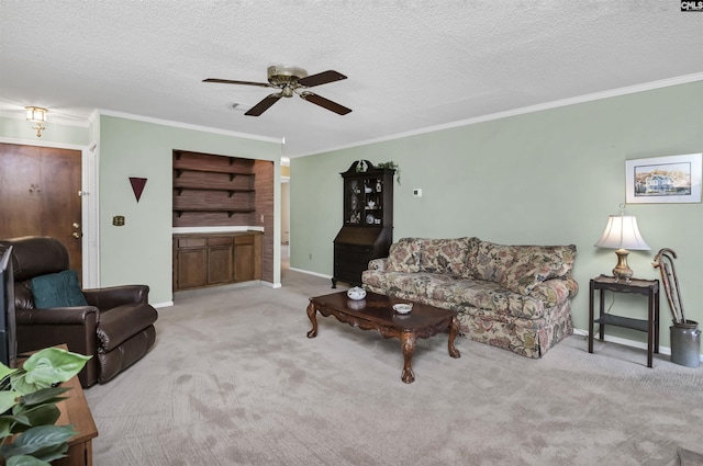 carpeted living room featuring ceiling fan, a textured ceiling, baseboards, and crown molding