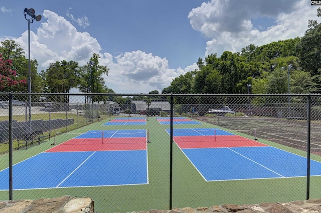 exterior space with a tennis court and fence