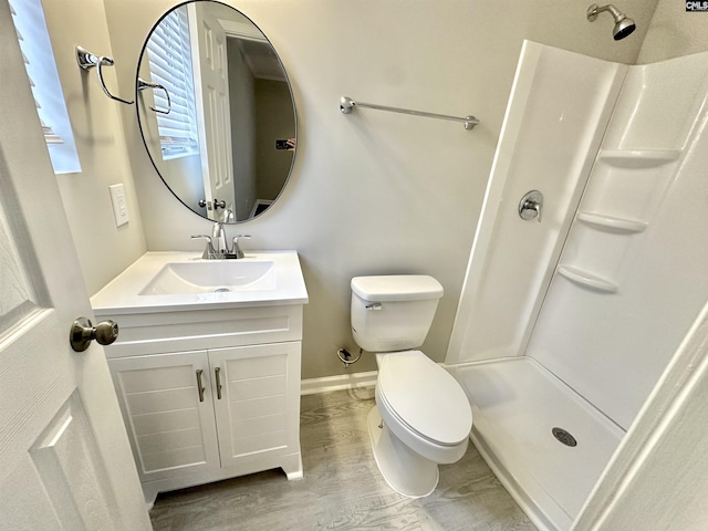 full bath featuring toilet, a shower stall, vanity, and wood finished floors