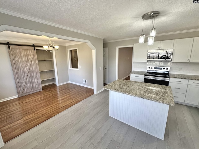 kitchen with appliances with stainless steel finishes, light wood-type flooring, light stone counters, and white cabinets