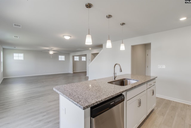 kitchen featuring light wood-style flooring, a sink, visible vents, stainless steel dishwasher, and pendant lighting