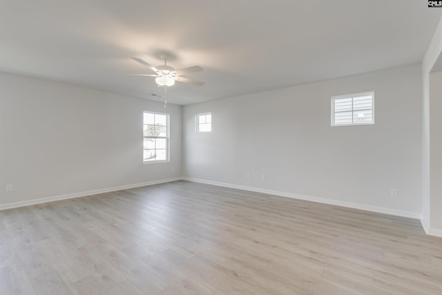 spare room featuring ceiling fan, light wood finished floors, visible vents, and baseboards