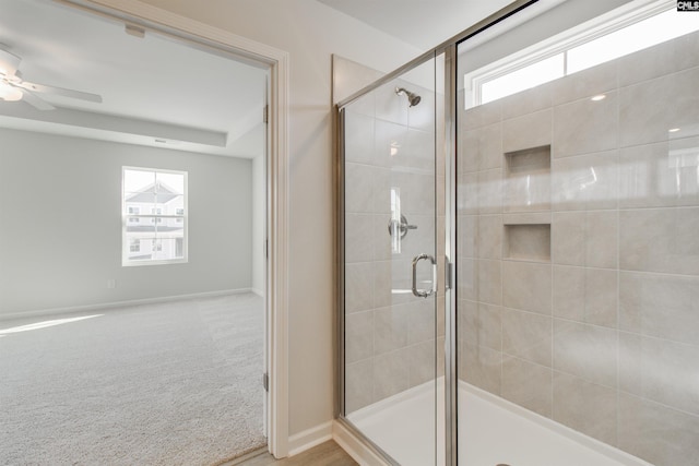 bathroom with a stall shower, baseboards, and a ceiling fan