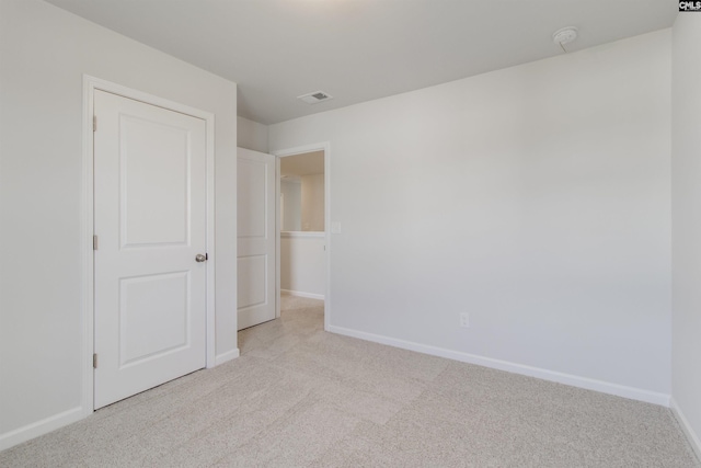 unfurnished bedroom featuring visible vents, baseboards, and light colored carpet