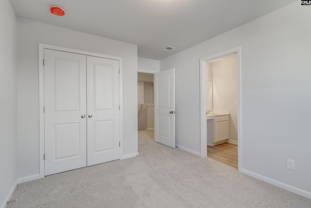 unfurnished bedroom with a closet, carpet flooring, visible vents, and baseboards