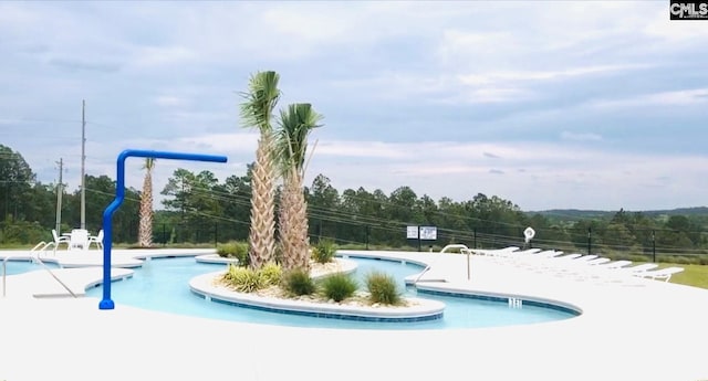 community pool with a patio area and fence