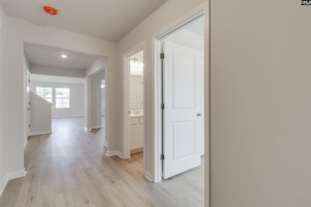 hallway featuring light wood-style floors and baseboards