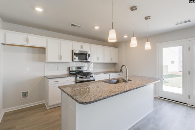 kitchen featuring stainless steel appliances, visible vents, a sink, and backsplash