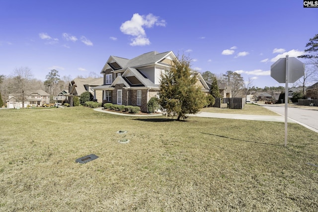 view of front of home featuring brick siding, a residential view, and a front yard