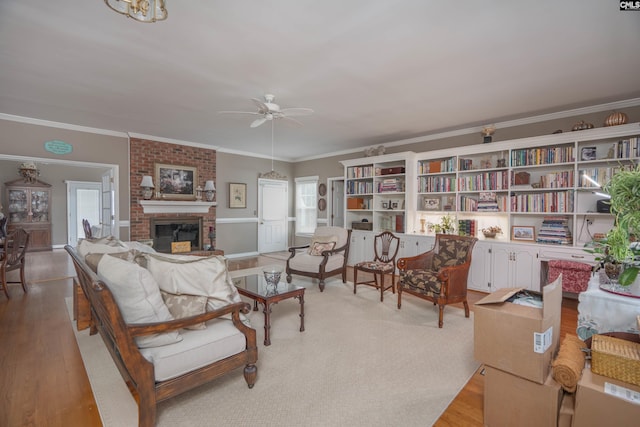 interior space featuring ornamental molding, light wood-type flooring, a fireplace, and ceiling fan