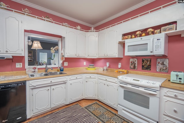 kitchen with white appliances, ornamental molding, white cabinets, and a sink