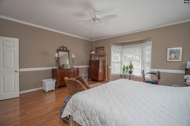 bedroom featuring ornamental molding, light wood-type flooring, baseboards, and a ceiling fan