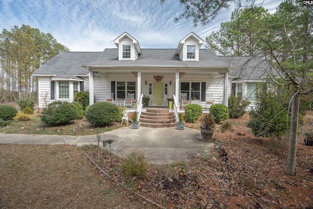 cape cod home featuring covered porch