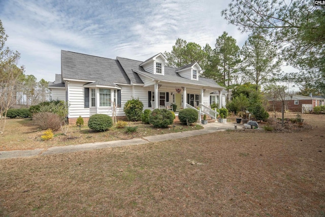 cape cod house featuring a porch