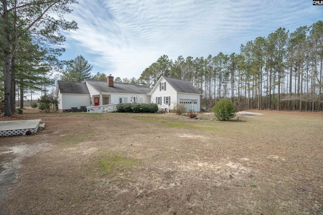 view of front of property featuring a garage and a chimney