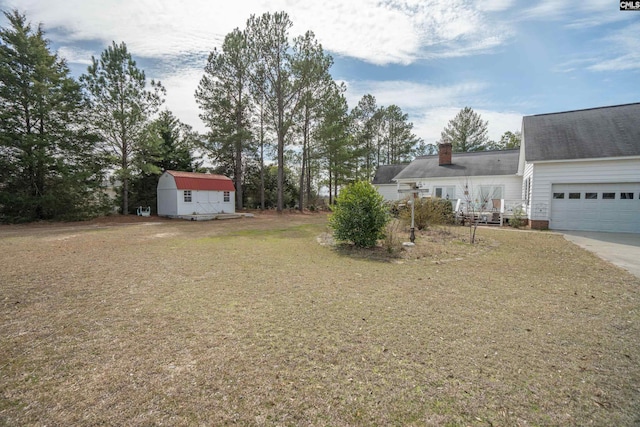 view of yard featuring a garage and concrete driveway