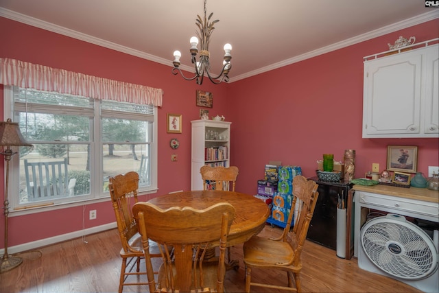 dining area featuring a chandelier, ornamental molding, light wood-type flooring, and baseboards