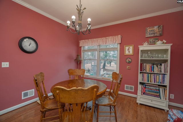 dining area featuring wood finished floors, visible vents, and crown molding