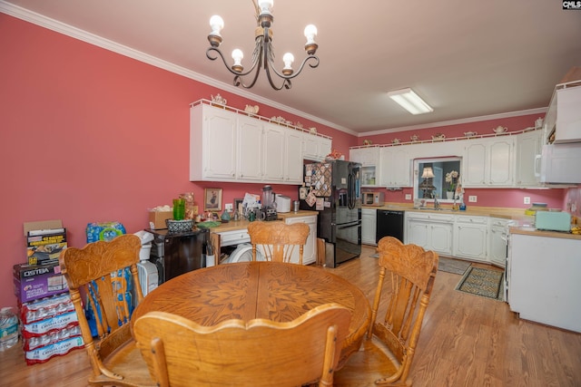 dining room with light wood-type flooring, an inviting chandelier, and ornamental molding