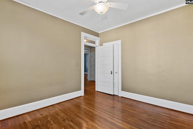 unfurnished room with a ceiling fan, crown molding, baseboards, and wood finished floors