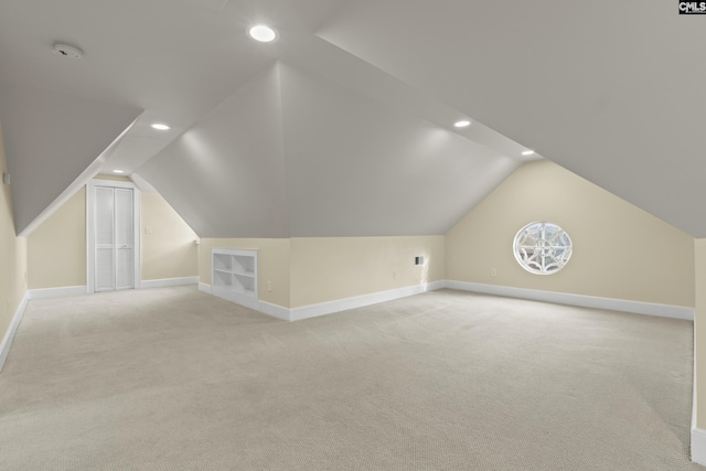 additional living space featuring baseboards, recessed lighting, and light colored carpet