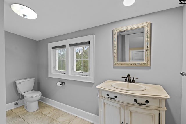 bathroom featuring tile patterned floors, vanity, toilet, and baseboards