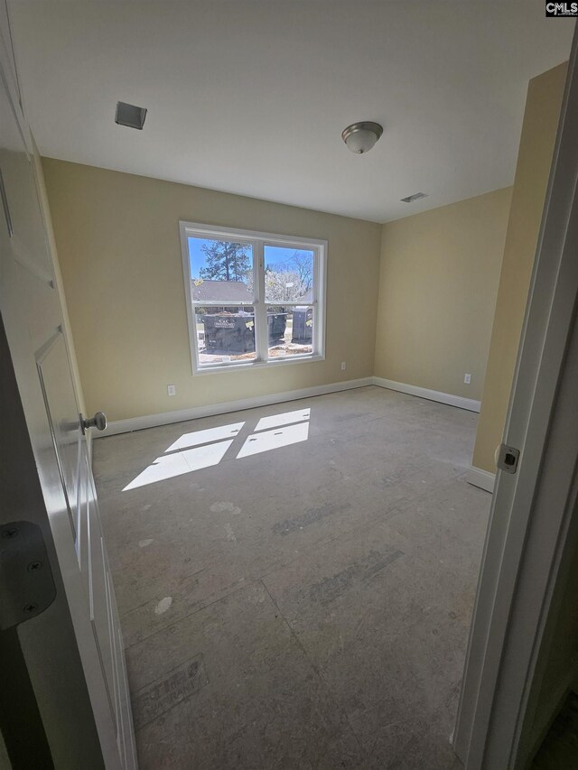 unfurnished room featuring visible vents and baseboards