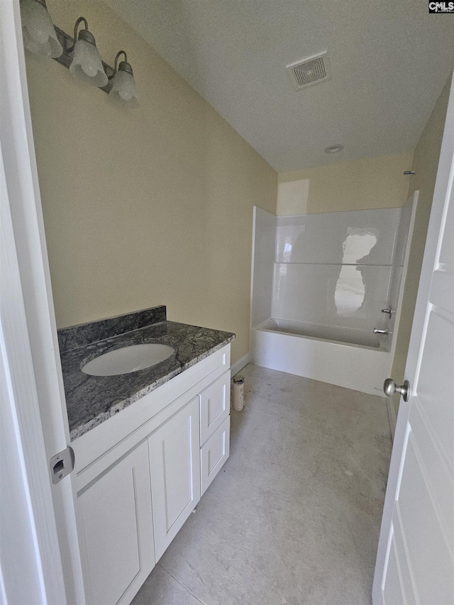 bathroom with tub / shower combination, vanity, and visible vents