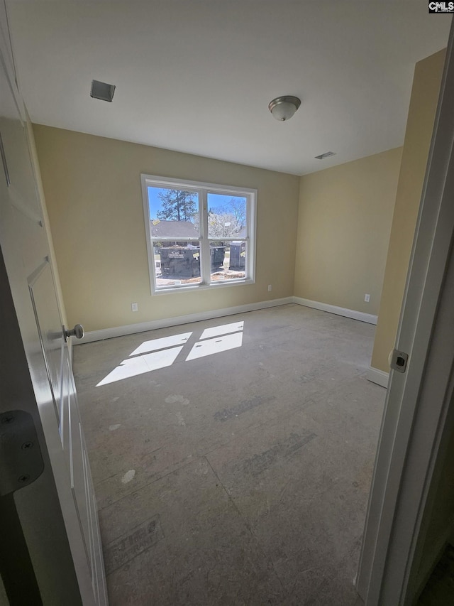 spare room featuring visible vents and baseboards