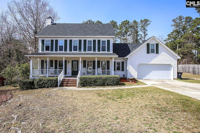 colonial house featuring driveway, a garage, a chimney, covered porch, and a front lawn